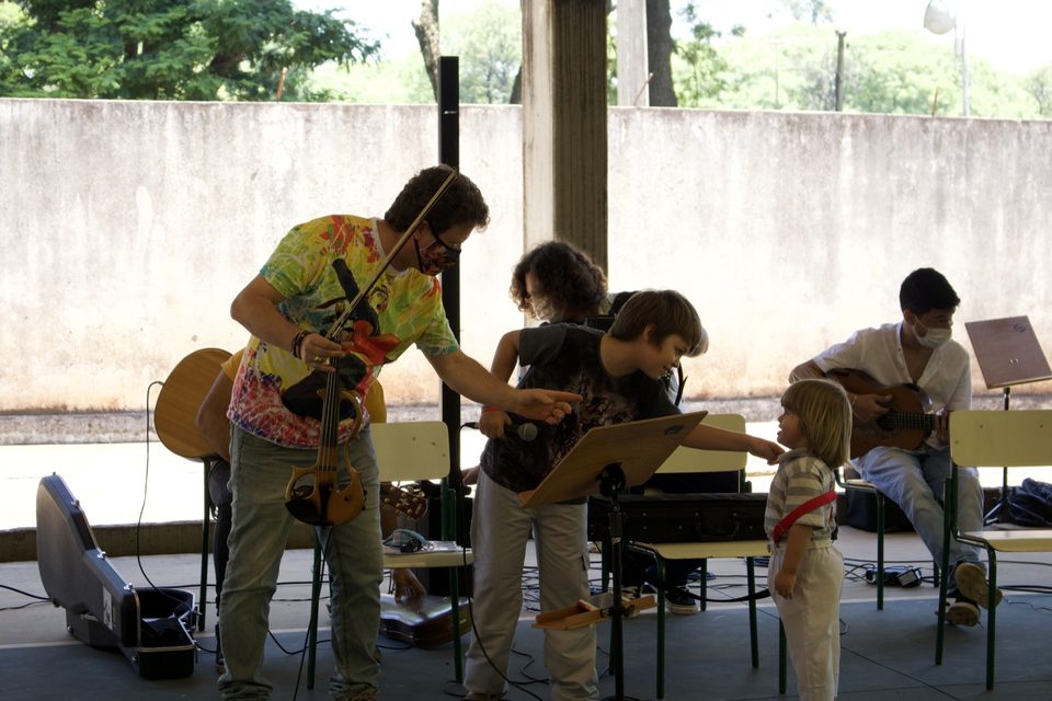 Roney Marczak mostra o violino a duas crianças.
