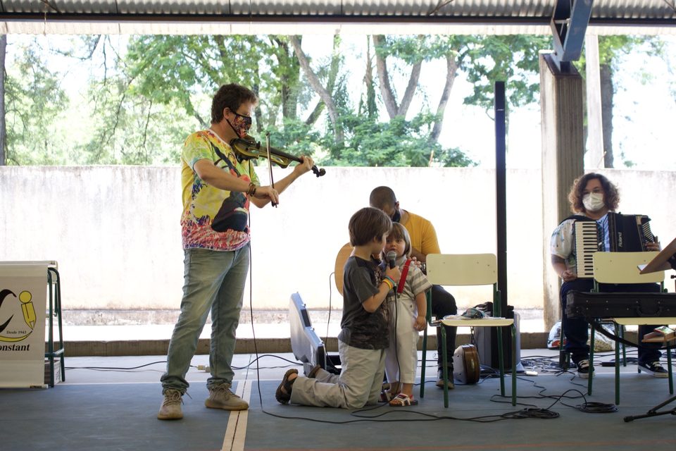 Roney Marczak toca violino para as crianças; ao lado, a sanfona.