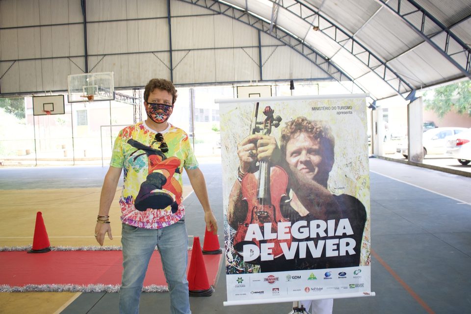 Roney Marczak faz sinal de positivo ao lado do banner do disco.
