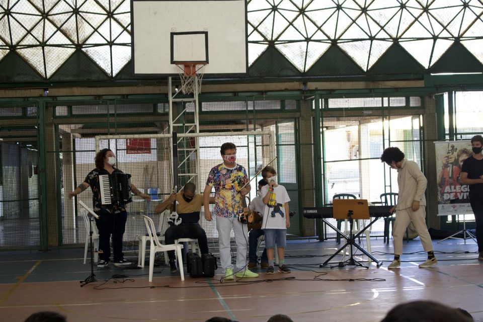 Roney Marczak e os músicos tocam com dois alunos no centro da quadra.