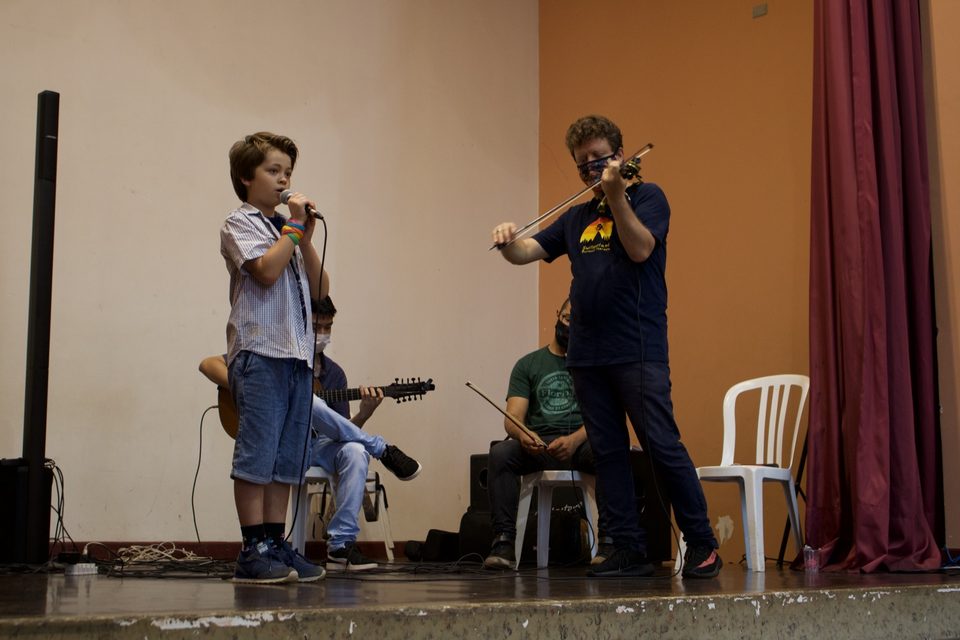 O menino canta enquanto Roney Marczak toca violino.