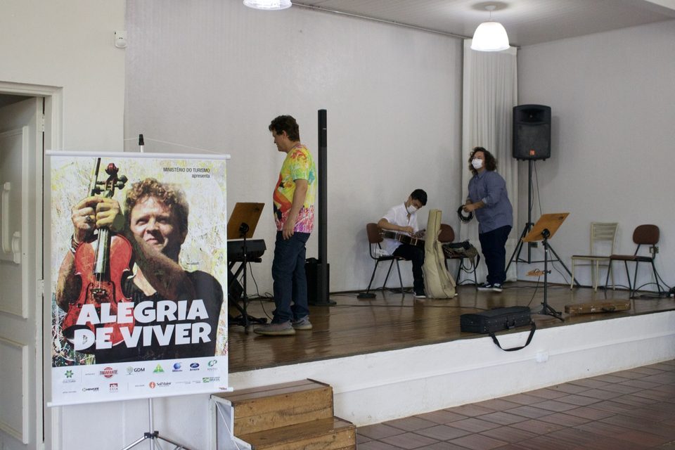 O banner do disco ao lado do palco, enquanto os músicos se preparam.