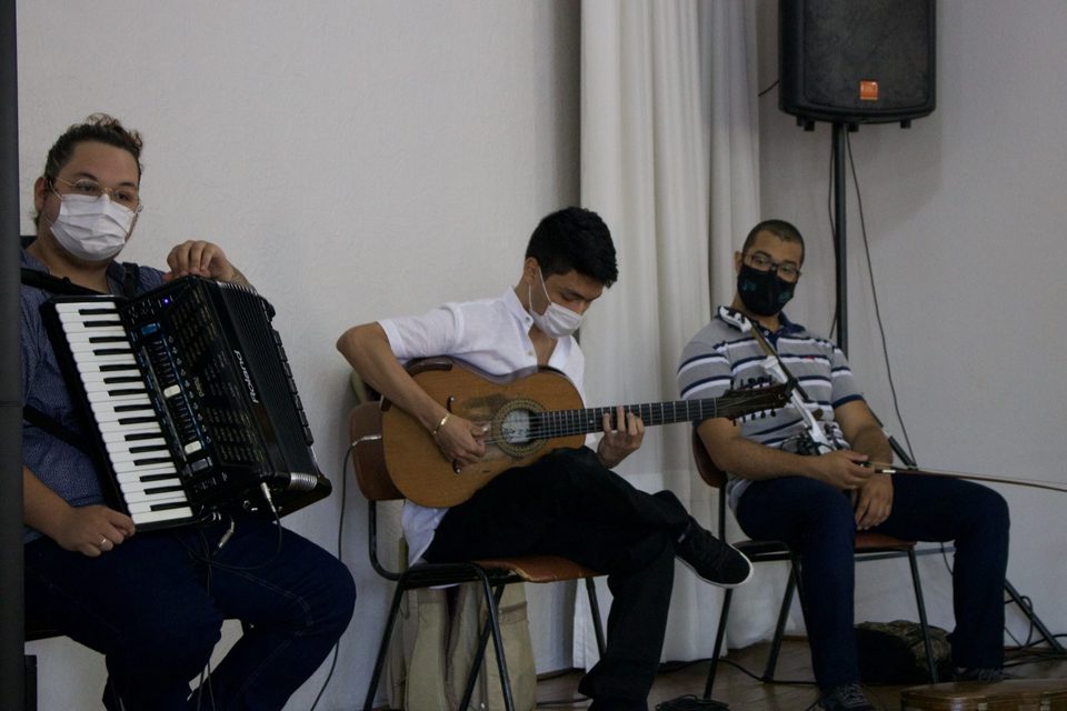 Sanfona, violão e violino elétrico tocados lado a lado.