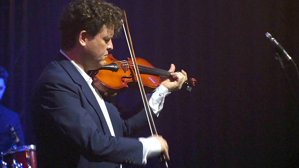 Roney Marczak toca violino com a cabeça inclinada sobre o instrumento.
