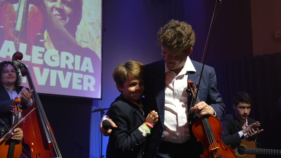 No fim do show, o menino e Roney Marczak no palco, diante do telão.